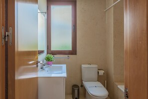 Een haardroger, een bidet, handdoeken, toiletpapier