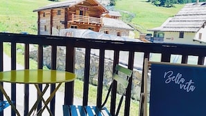 A balcony with a view of a mountain, a wooden cabin, and a sign that reads 'Bella vita'. - IN NEED OF FRESH AIR, NATURE AND CALM? (Molines-en-Queyras)