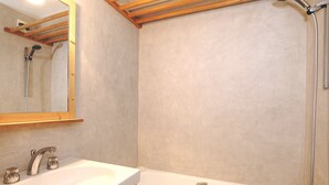 A bathroom with a wooden vanity, a large mirror, a bathtub, and a shower. - Charming mini-studio in Courchevel 1850 with parking (Courchevel 1850)