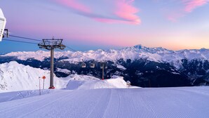 A snow-covered ski slope with a cable car system and a mountain range in the background. - Charming mini-studio in Courchevel 1850 with parking (Courchevel 1850)