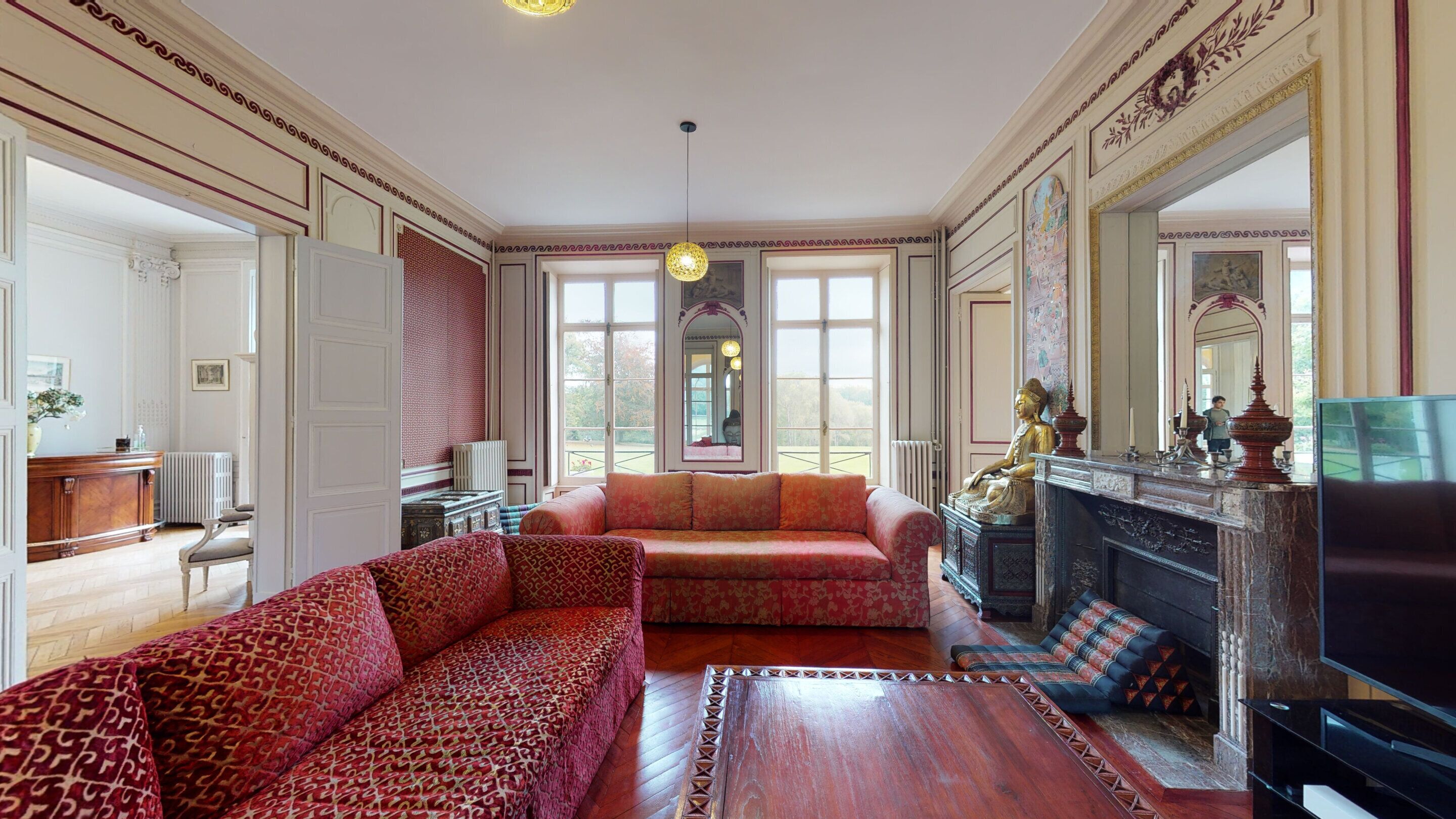 A spacious living room with a large sofa, a fireplace, and a television.