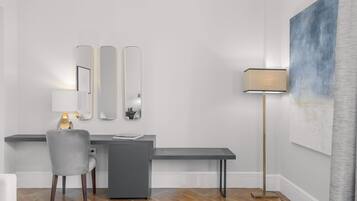 A modern room with a desk, chair, and a large abstract painting on the wall.