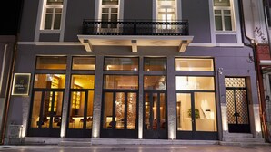 Een hotel met meerdere verdiepingen, verlichte ramen en een balkon.