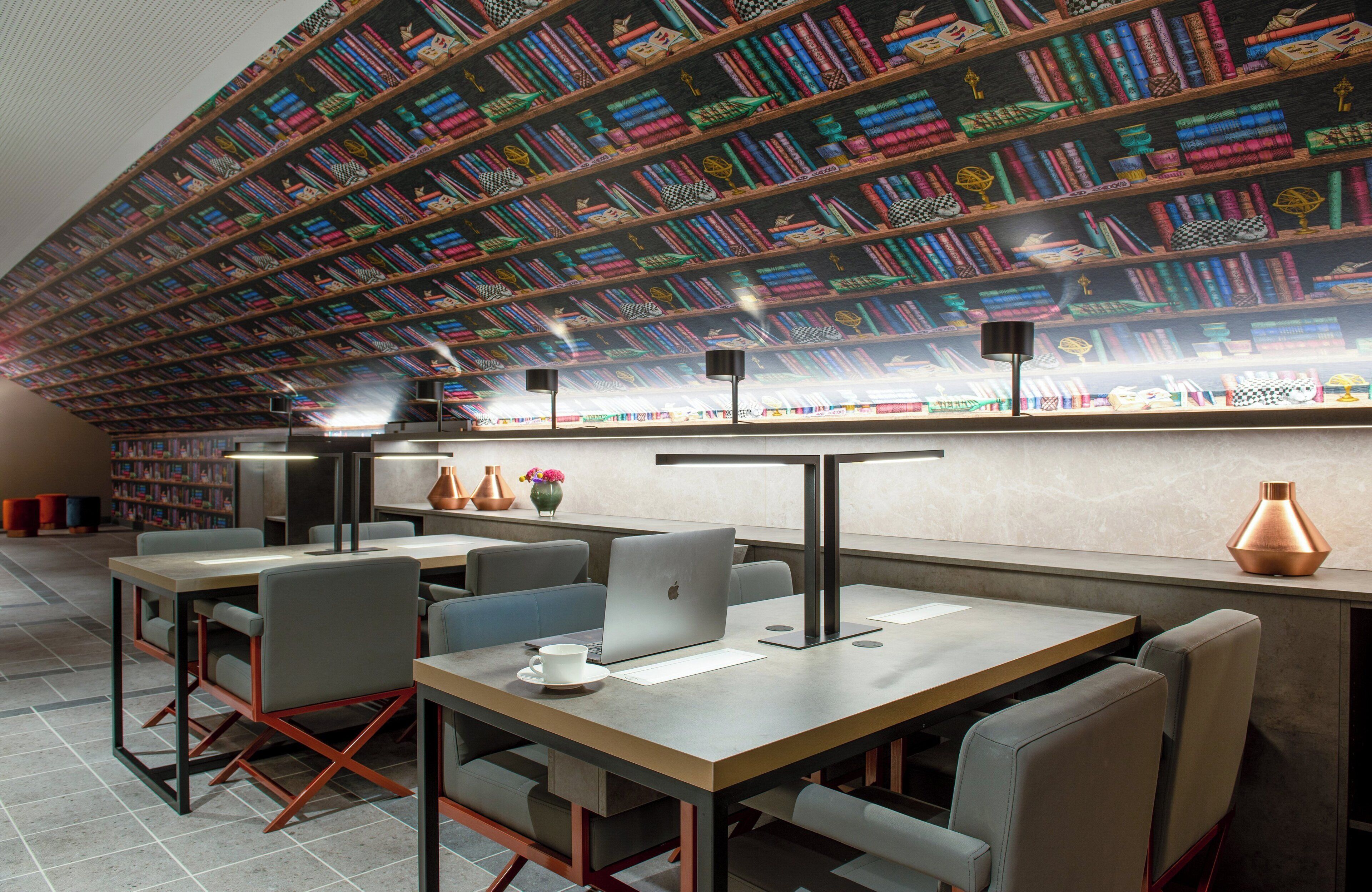 Eine moderne Bibliothek mit Bücherregalen, Tischen und Stühlen.