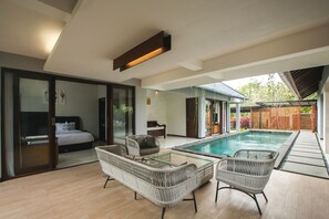 A modern home with a glass-enclosed bedroom, a pool, and outdoor seating. - Villa Ciwuwi Balangan by Nagisa Bali (Jimbaran)