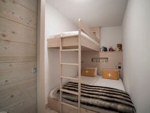 A bunk bed with a wooden ladder, a shelf with books and toys, and a 'HOME' sign on the wall. - Modern apartment in Courchevel 1550 with electric box and wifi (Courchevel 1550)