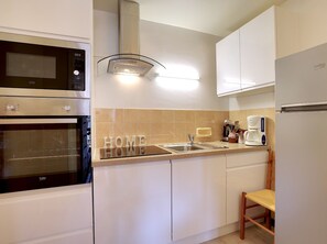 A modern kitchen with a built-in oven, a microwave, a sink, and a coffee maker. - Charming apartment in central Courchevel 1550, direct access to Courchevel 1850 (Courchevel 1550)
