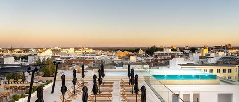 Piscine couverte, piscine extérieure, parasols de plage, chaises longues