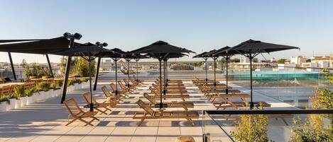 Piscine couverte, piscine extérieure, parasols de plage, chaises longues