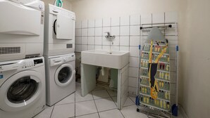 A laundry room with a washing machine, dryer, and ironing station. - Elegant duplex in Courchevel 1850 with fireplace and private parking (Courchevel 1850)