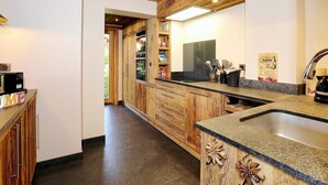 Eine Küche mit Holzausstattung, einer Granitarbeitsplatte und einem Edelstahlspülbecken.