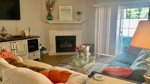 A living room with a fireplace, a sofa, a coffee table, and a television.