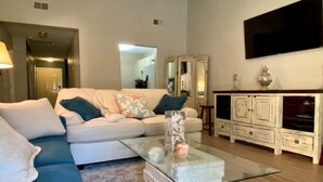 A living room with a sofa, a coffee table, a TV, and a cabinet.
