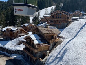 Une station de ski avec des chalets en bois, un télésiège et des pistes enneigées.