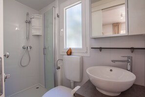 Shower, pengering rambut, handuk, dan tisu toilet