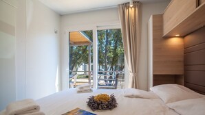 Ein Hotelzimmer mit Bett, Blick ins Freie und einem Vorhangfenster.
