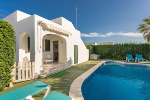 Une villa blanche dotée d’une piscine, d’un patio couvert et offrant une vue sur la mer.