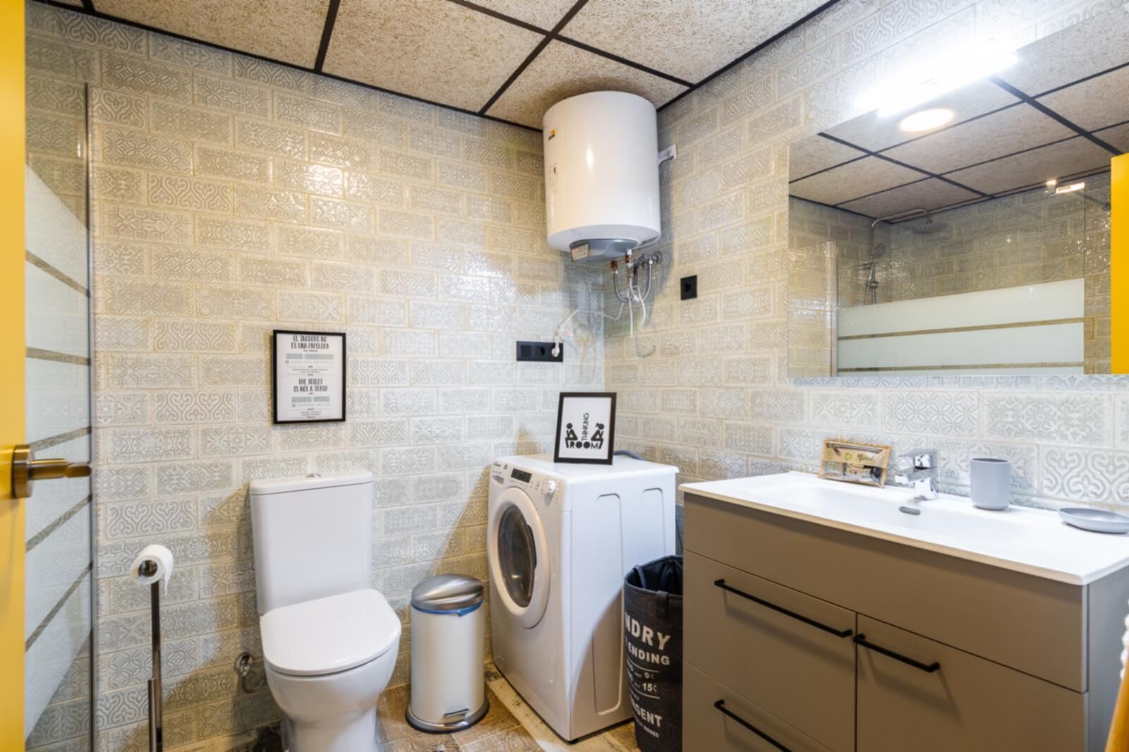 Un baño pequeño con inodoro, lavadora y lavamanos.