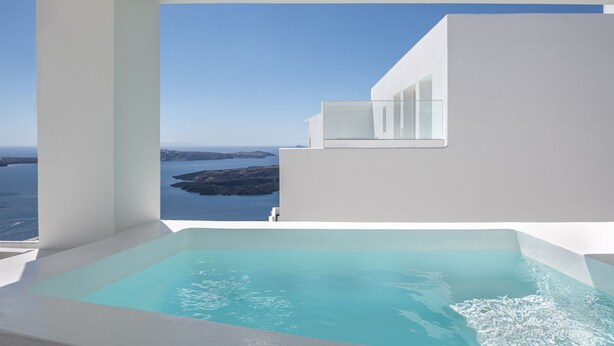 A modern pool area with a clear view of the sea and rocky coastline. - Akra Suites & Spa (Santorini)