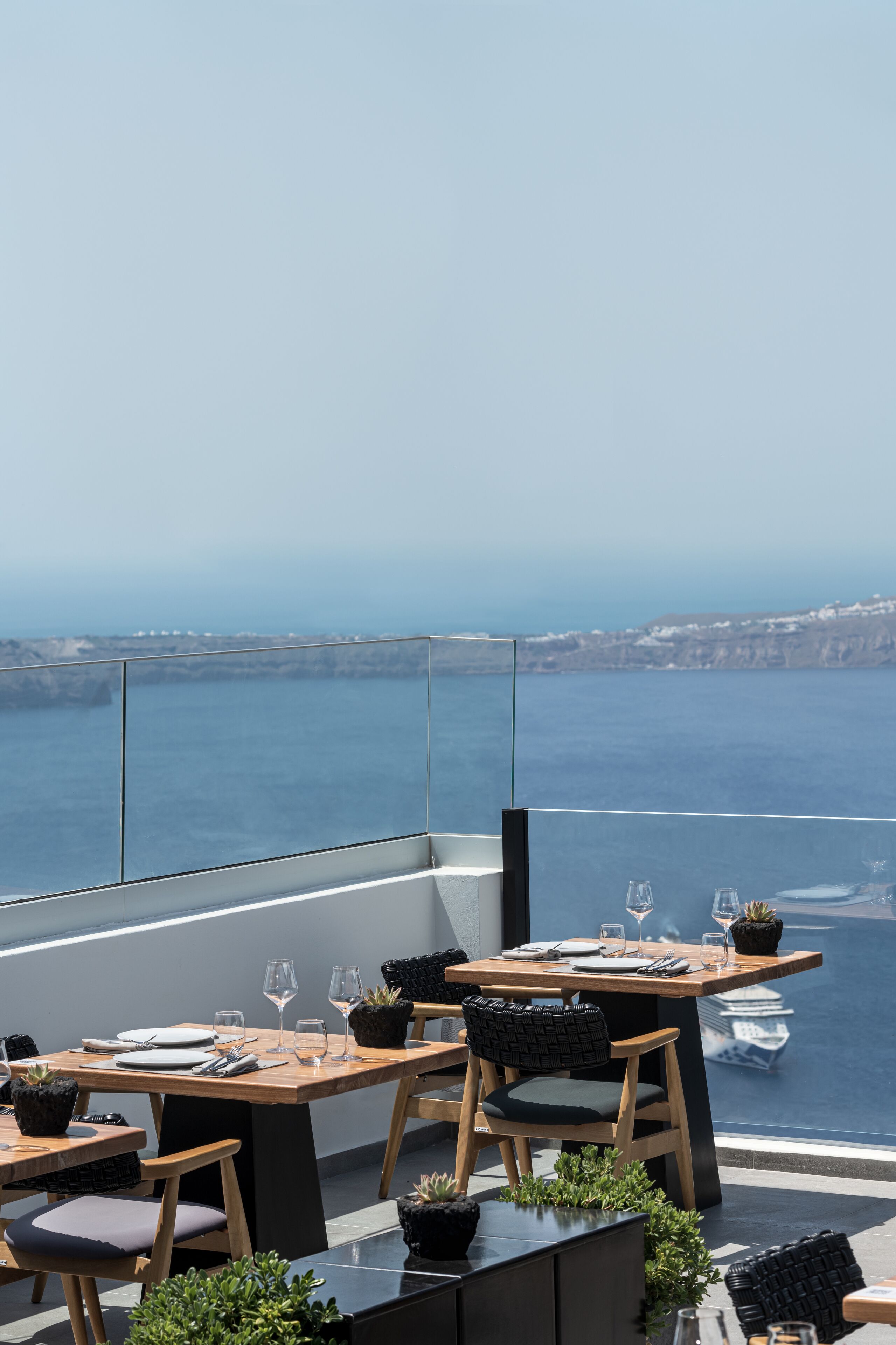 Un espace de restauration aménagé sur le toit, avec des tables et des chaises, offrant une vue sur la côte.