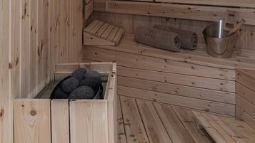 Una sauna in legno con panche, un sedile e un altro sedile con un asciugamano.