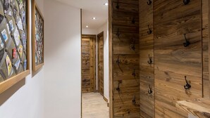 Un pasillo con paneles de madera y ganchos negros en las paredes.