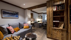Una sala de estar moderna con un sofá gris, una estantería de madera y un tablero de ajedrez.