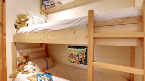 Un lit superposé à deux niveaux, chaque niveau étant équipé d’un oreiller et d’un jouet en peluche.