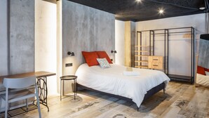 A modern bedroom with a bed, bedside table, and a desk. - Art Loft 06 'Travelling Light' in Valencia (València)