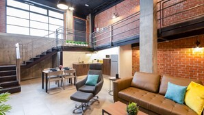 A spacious loft with a kitchen, dining area, and a staircase leading to an upper level. - Art Loft 06 'Travelling Light' in Valencia (València)