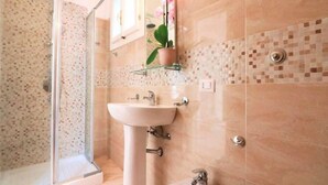 A bathroom with a shower, sink, and toilet. - Sorrento Historical Center (Sorrento)
