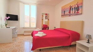 A hotel room with a bed, a desk, a TV, and a painting on the wall. - Sorrento Historical Center (Sorrento)