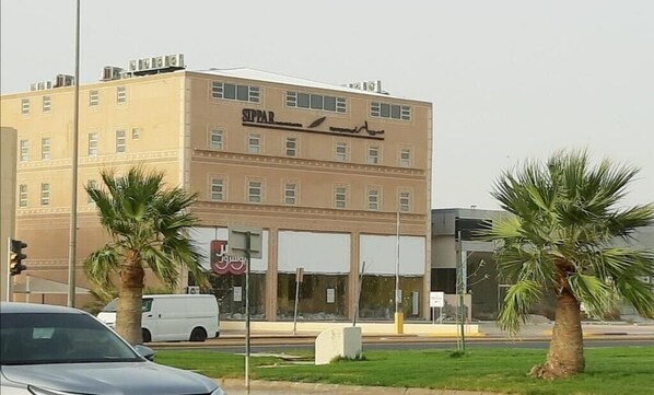 A multi-story building with a sign that reads "SIPPAR" in Arabic.