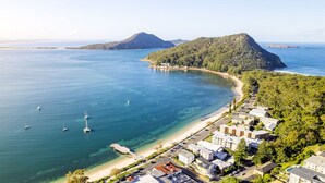 A coastal area with a beach, boats, and residential buildings. - Albacore 7, 12 Ondine Close, Waterfront Unit with (Nelson Bay)