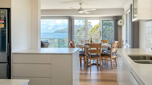 A modern kitchen with a dining area overlooking a scenic view. - Albacore 7, 12 Ondine Close, Waterfront Unit with (Nelson Bay)