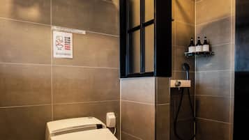 Un baño moderno con inodoro, zona de ducha y perchero.