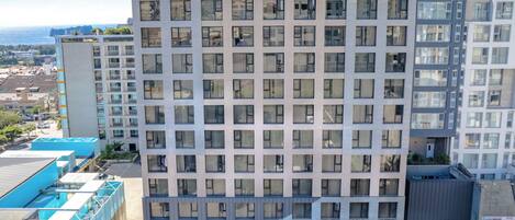 Un hotel de varios pisos con fachada moderna, múltiples balcones y acceso en planta baja.