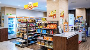 A well-lit convenience store with a variety of snacks, beverages, and a self-checkout machine. - Tamara Jeju (Seogwipo)