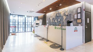 A reception desk with a world map, a clock, and a sign for 'Tamaru'. - Tamara Jeju (Seogwipo)