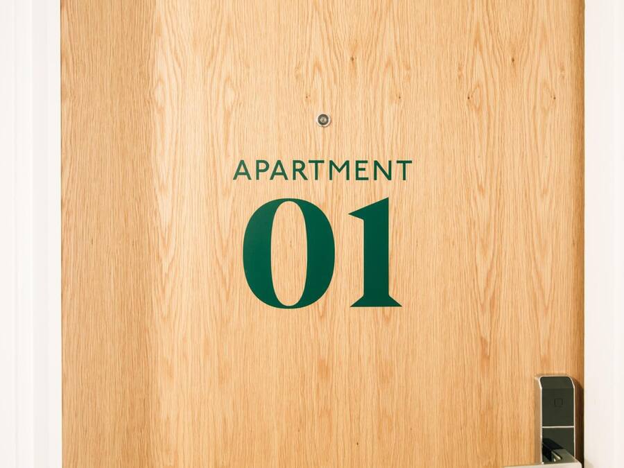 A wooden door with the text "APARTMENT 01" indicating the apartment number.