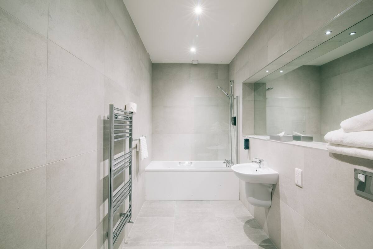 A modern bathroom with a bathtub, a sink, and a glass shower enclosure.