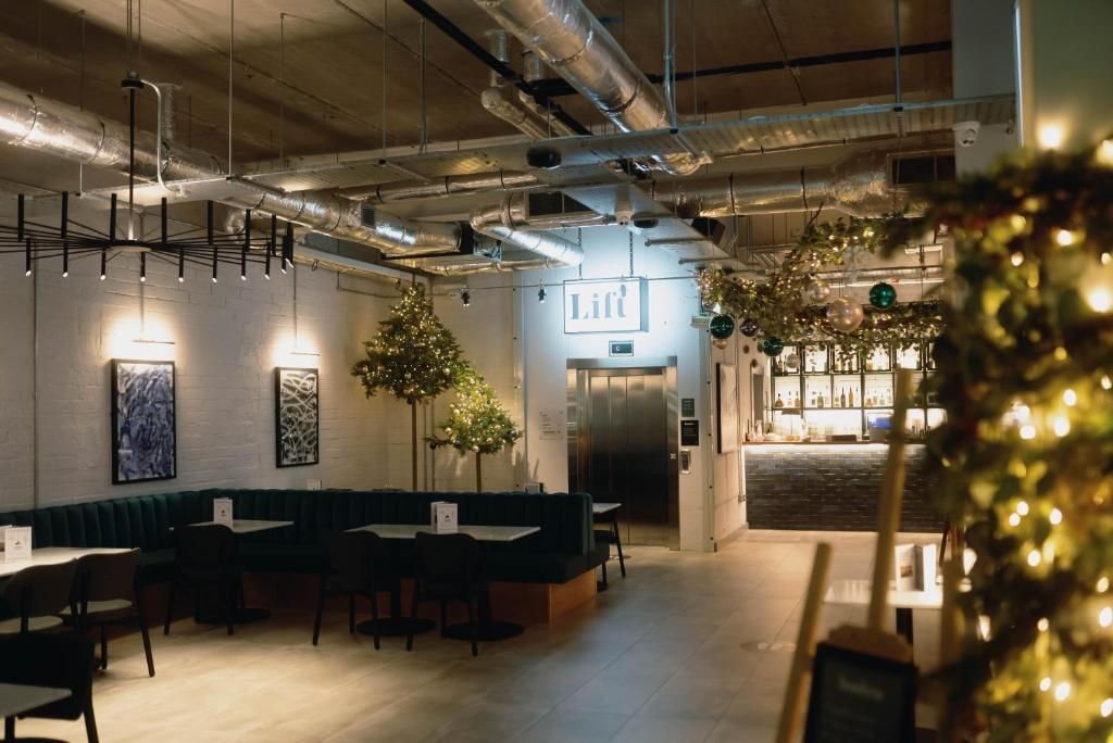 A restaurant with a bar area, a Christmas tree, and a sign that reads 'Lift'.