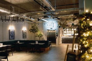 Un restaurante con zona de bar, un árbol de Navidad y un cartel que dice 'Lift'.