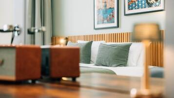 Una habitación de hotel con cama, cabecero de madera y un cuadro en la pared.