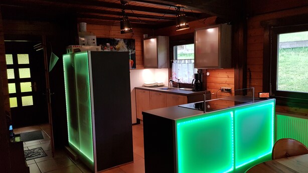 Una cocina moderna con una isla central, armarios de madera y un ventanal con vistas al exterior.
