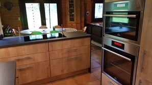Una cocina moderna con armarios de madera, un horno de acero inoxidable y una isla grande con fregadero.