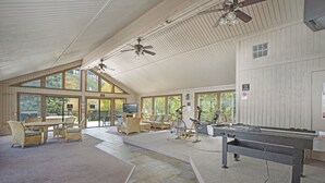 A spacious indoor area with a pool table, comfortable seating, and large windows offering views of the outdoors. - Ridgecrest 202 2 Bedroom Condo by RedAwning (Steamboat Springs)