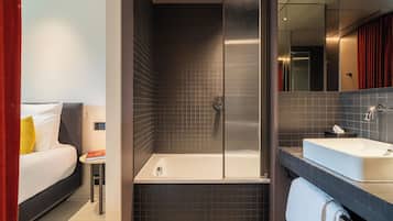 A modern bathroom with a bathtub, a sink, and a shower.