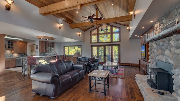 A spacious living area with a leather sofa, a coffee table, and a stone fireplace. - 5 Bedroom close to Town, hot tub, BBQ(SL437) (Stateline)