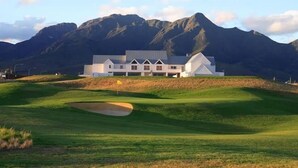 Un parcours de golf doté d’un club-house et offrant une vue imprenable sur les montagnes.